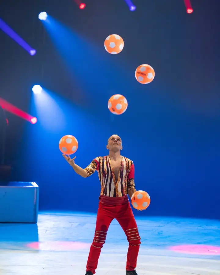 Jongleur Ivan Radev met ballen hoog in de lucht boven de piste